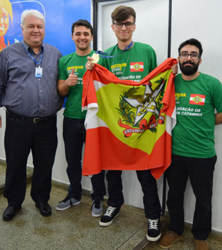 Vencedor segura a bandeira do estado, junto de colegas.